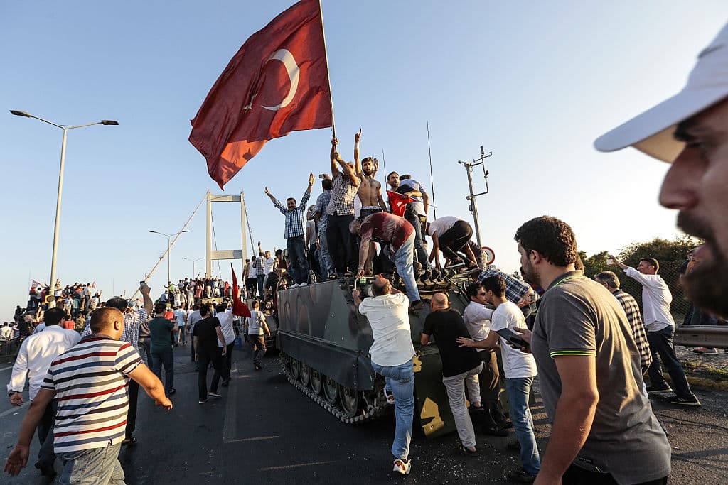 Ciudadanos progubernamentales celebran sobre un tanque el fracaso del golpe militar contra Erdogan.