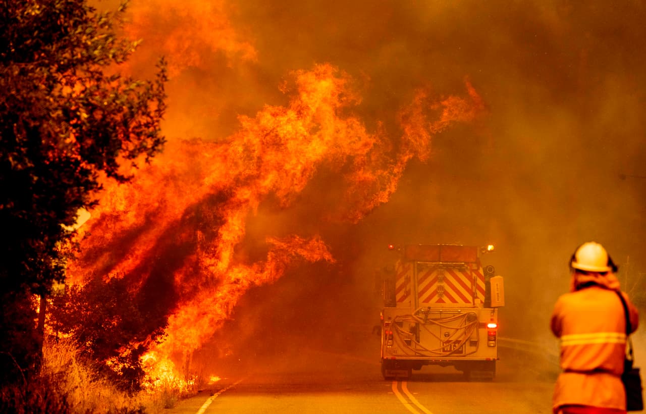 Un camión de bomberos atraviesa las llamas mientras un incendio continúa descontrolado cerca del lago Berryessa en Napa.