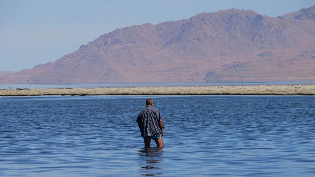 Un hombre entra en el Gran Lago Salado y podemos ver 
<b>el bajo nivel del agua</b>, el viernes 26 de agosto de 2022, cerca de Salt Lake City.