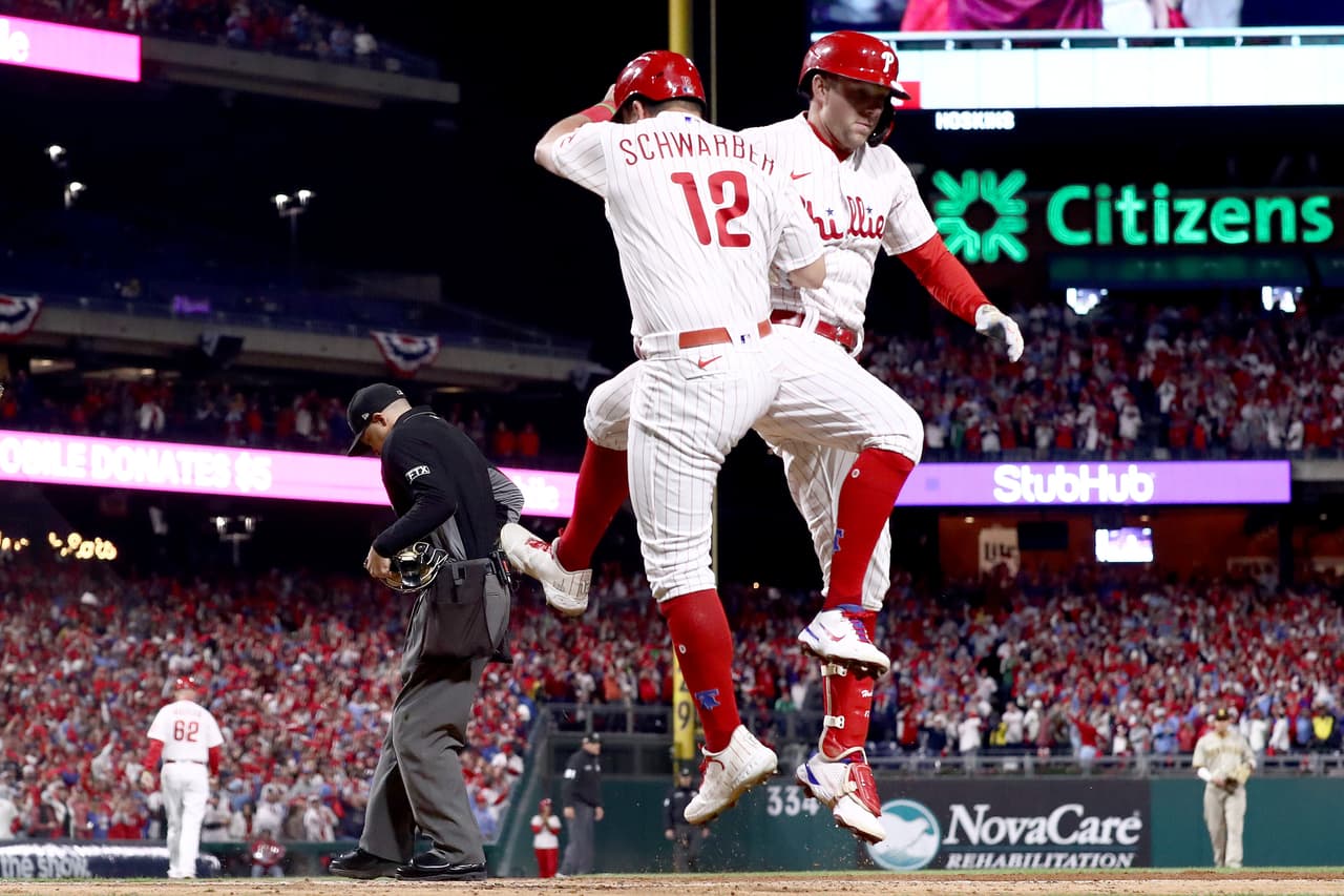Los 
<b>Phillies </b>perdían 4-0 en el primero y luego se desprendieron, se alejaron y dieron un gran espéctaculo a los fánaticos que llenaron el Citizens Bank Park. En la foto, 
<b>Rhys Hoskins</b> #17 y 
<b>Kyle Schwarber </b>#12 celebran un jonrón de dos carreras de Hoskins durante la primera entrada contra los Padres de San Diego en el cuarto juego de la 
<b>Serie de Campeonato de la Liga Nacional</b>. 
<br>