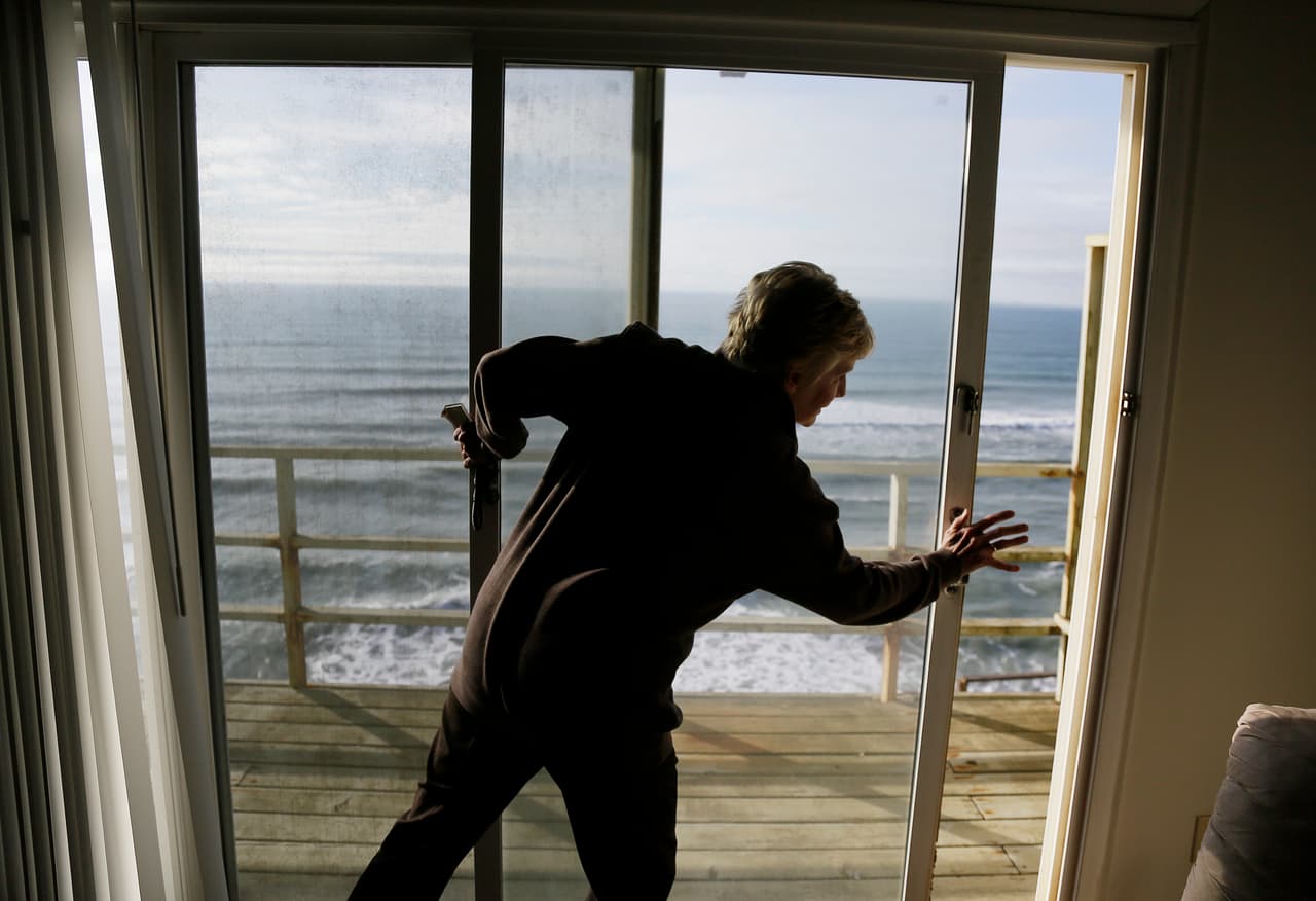 Una mujer cierra las ventanas de su apartamento en Pacifica (California) al verse obligada a abandonar la casa.