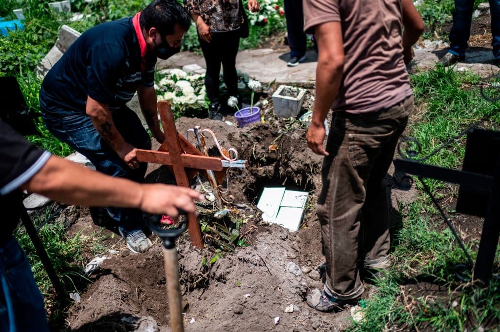 Familiares entierran las cenizas de un fallecido en el cementerio de San Miguel Xico el 5 de agosto de 2020, en medio de la pandemia. 
<br>
