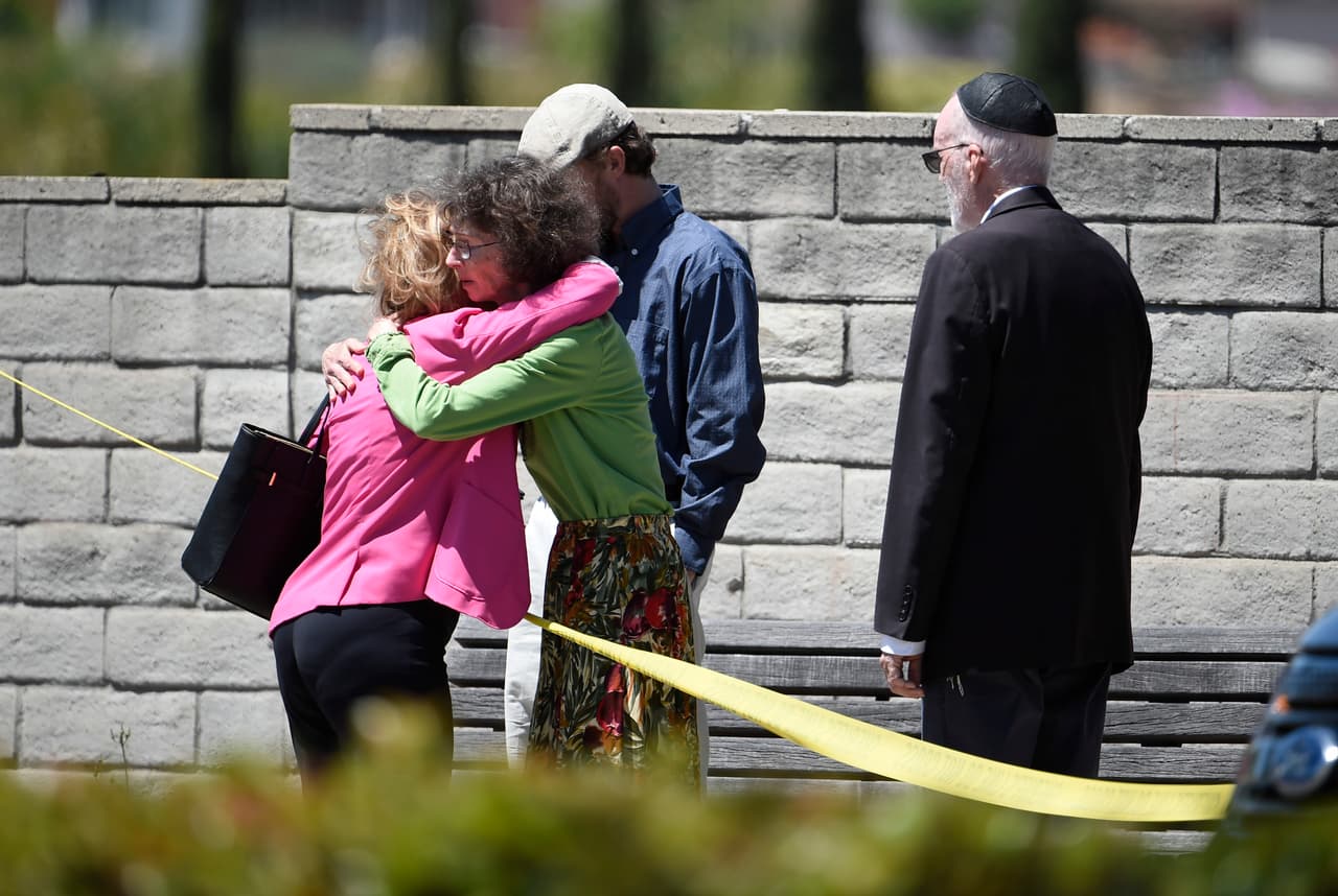 Los miembros de la sinagoga Chabad en la ciudad Poway, en San Diego, California, se consuelan unos a otros luego de 
<b><a href="https://www.univision.com/noticias/tiroteos/al-menos-un-muerto-y-tres-heridos-tras-tiroteo-en-un-tiroteo-en-una-sinagoga-en-california">un tiroteo ocurrido poco antes</a></b> en el que 
<b>una mujer falleció y otras tres personas resultaron heridas,</b> entre ellos una niña.