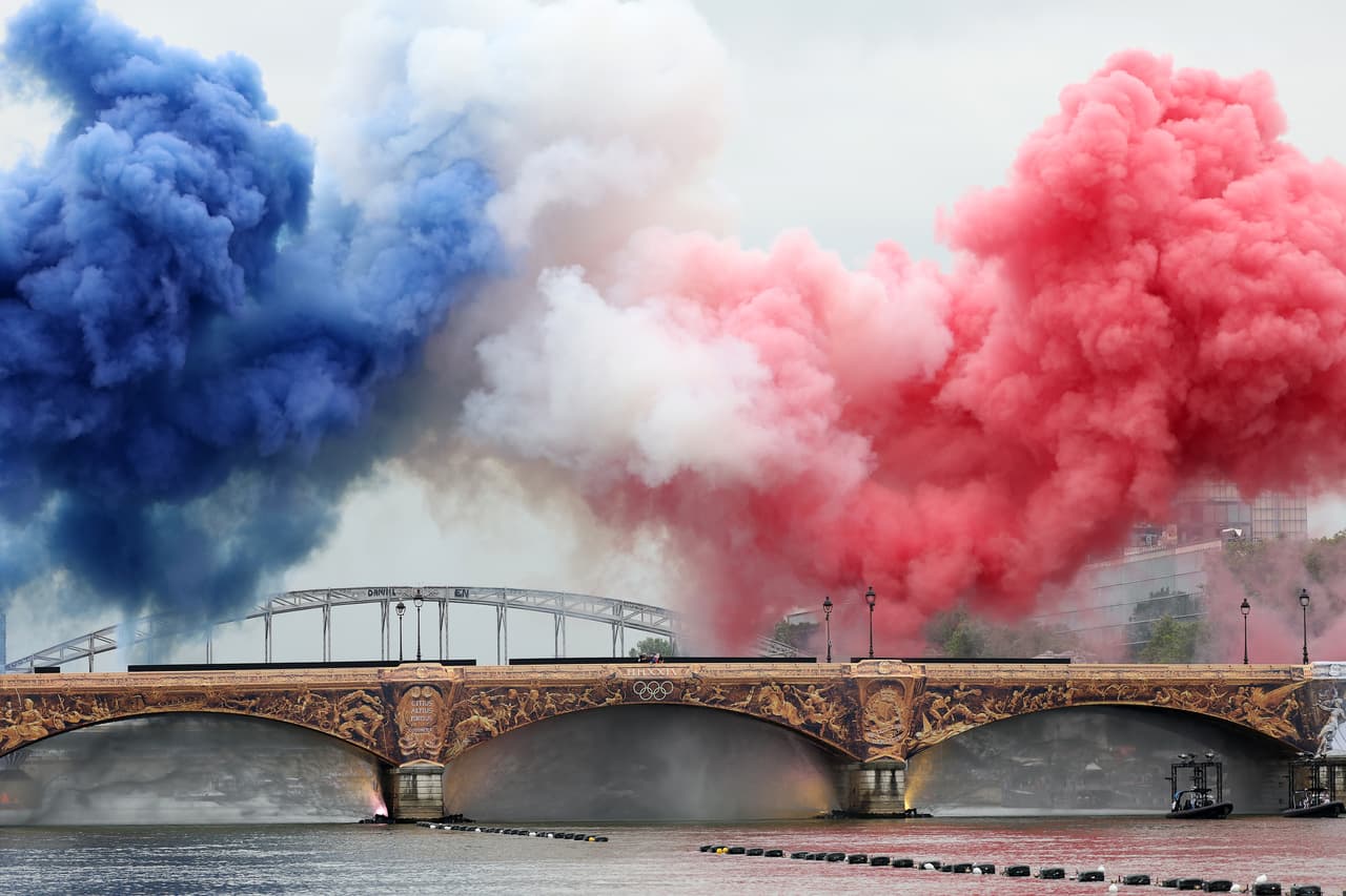 Los colores de la bandera francesa iluminaron el cielo en las orillas del Río Sena que recibió a cientos de asistentes.
<br>