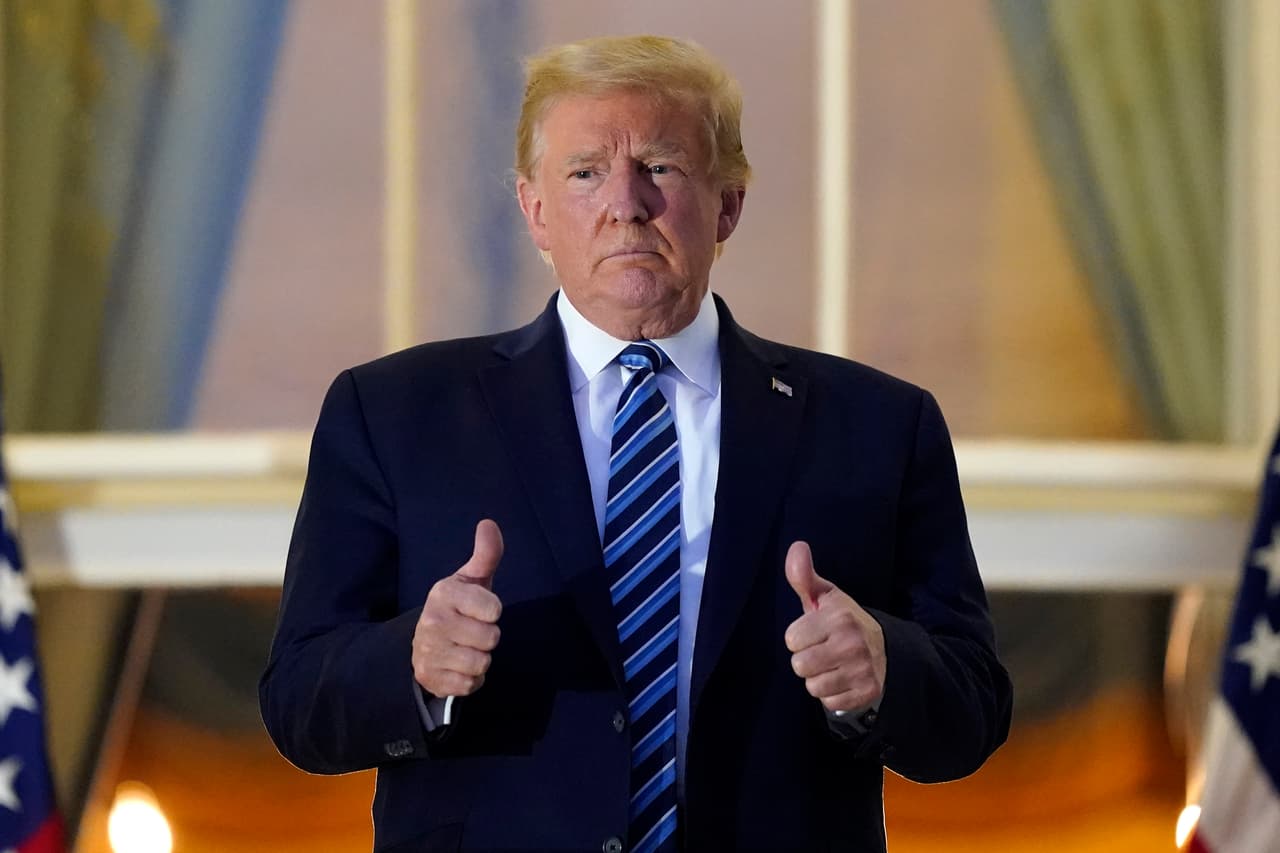 Donald Trump saluda desde un balcón a su regreso a la Casa Blanca del hospital Walter Reed.