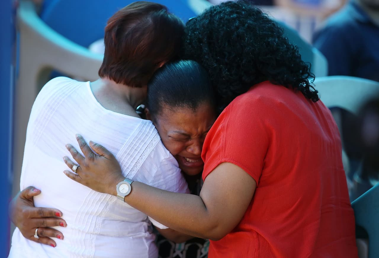 Familiares y amigos de las víctimas del tiroteo de la secundaria Marjory Stoneman Douglas hacen una vigilia al día siguiente de la tragedia en una iglesia de la comunidad.
