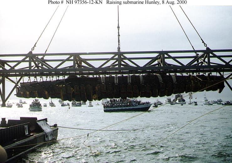 En 1995, la Agencia Nacional de Subacuática y Marina (NUMA) halló el Hunley. La Marina de EEUU logró recuperarlo el 8 de agosto de 2000. La imagen fue tomada justo después de que fuera extraído del fondo del mar frente a Charleston, Carolina del Sur.
