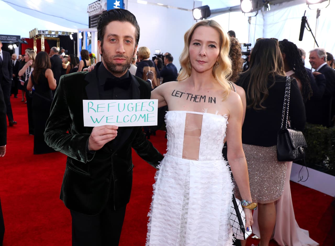 Los actores Simon Helberg y Jocelyn Towne protestan contra el decreto de Trump, en la alfrombra roja de los premios SAG.