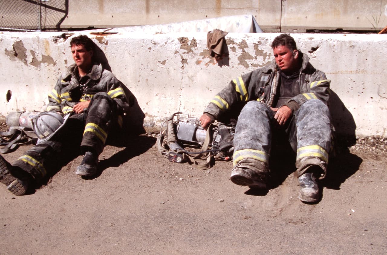 Bomberos en el suelo extenuados durante las labores de rescate. Ese día perdieron la vida 2,753 personas, entre ellos 343 bomberos de Nueva York, 23 policías de la ciudad y 37 agentes de la Autoridad Portuaria.
