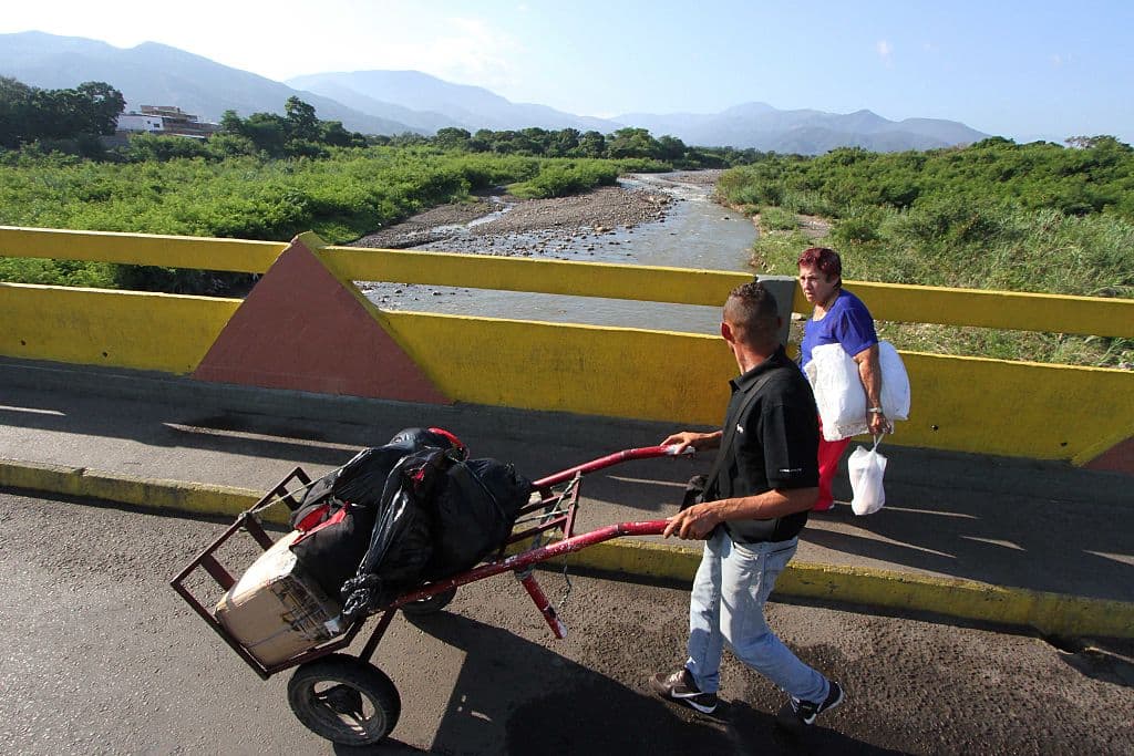 A man crosses the Simón Bolívar International Bridge of North Santander in Colombia back to San Antonio del Táchira, Venezuela, on December 17, 2017. Photo: GEORGE CASTELLANOS / AFP / Getty Images.