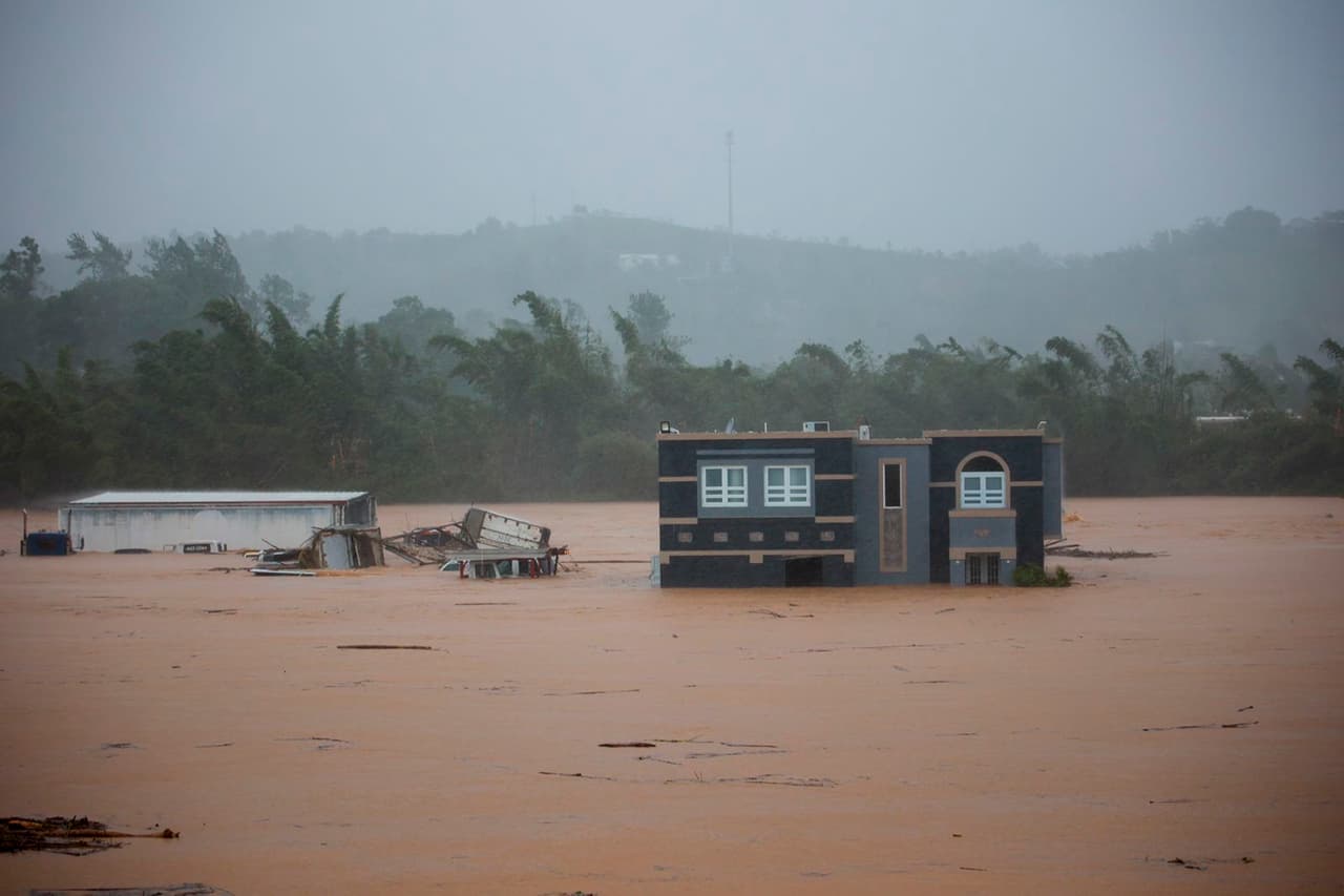 El centro del huracán Fiona se situó 10 millas (15 kilómetros) al oeste de Mayagüez con vientos máximos sostenidos de 85 mph (140 kph), según el Centro Nacional de Huracanes de Estados Unidos. Se movía hacia el noroeste a 9 mph (15 kph). En la foto, tres personas dentro de una casa en Cayey esperan ser rescatadas.