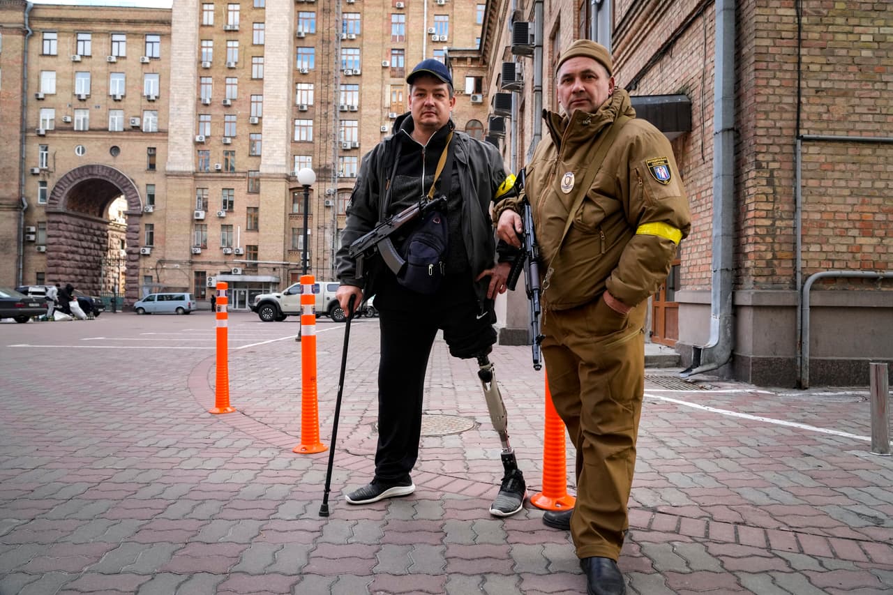 Un civil armado posa para una foto mientras patrulla una calle en Kiev, Ucrania, el domingo 27 de febrero de 2022. Hombres y mujeres se han ofrecido en masa como voluntarios. Formaron largas filas para conseguir armas y defender así a su país. 
<b>Algunos incluso regresaron del extranjero para unirse a la resistencia.</b>