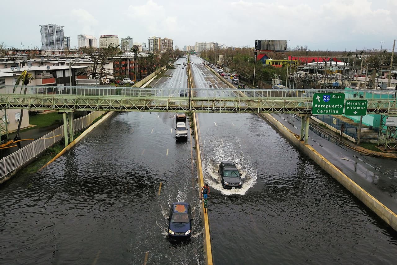 Los automóviles atraviesan las vías inundadas de San Juan, la capital.