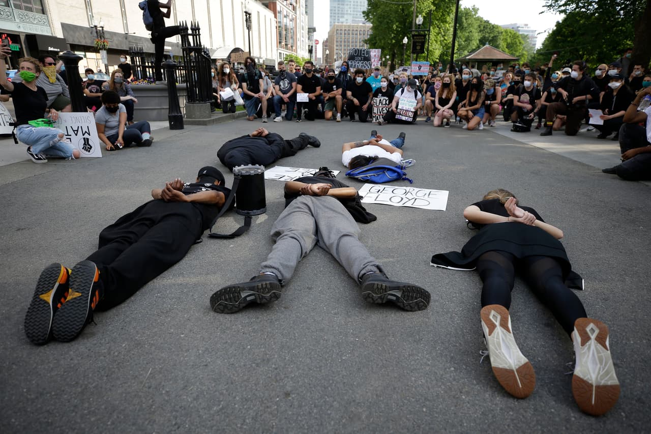 Manifestantes se acuestan boca abajo durante una protesta contra la brutalidad policial en el céntrico parque Boston Common, representando a George Floyd durante su detención por la policía de Minneapolis. Floyd fue inmovilizado por cuatro agentes; uno de ellos, Dereck Chauvin, 
<b><a href="https://www.univision.com/noticias/justicia/despiden-a-cuatro-policias-tras-video-que-muestra-como-asfixian-al-afroestadounidense-george-floyd-durante-su-arresto">mantuvo su rodilla presionando el cuello del afroestadounidense durante casi nueve minutos</a></b>, a pesar de que varias veces el detenido se quejaba de que no podía respirar.