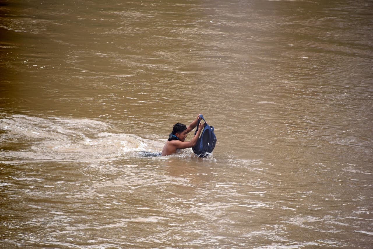 Uno de los migrantes pasando el río fornterizo.