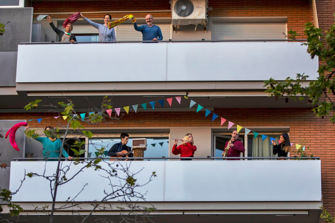 <b>El reencuentro entre vecinos</b>. Algunas ciudades tuvieron períodos de confinamiento largos y los balcones y ventanas se transformaron en el centro social. Conciertos, conversaciones, fiestas y manifestaciones se realizaron sin salir de casa. En la fotografía un cuarteto toca en un balcón y los vecinos 
<a href="https://www.univision.com/noticias/salud/fotos-en-la-era-del-coronavirus-y-la-cuarentena-los-balcones-son-el-centro-de-la-vida-social-fotos"><u>disfrutan y bailan la presentación</u></a>. Barcelona, España, 5 de abril.