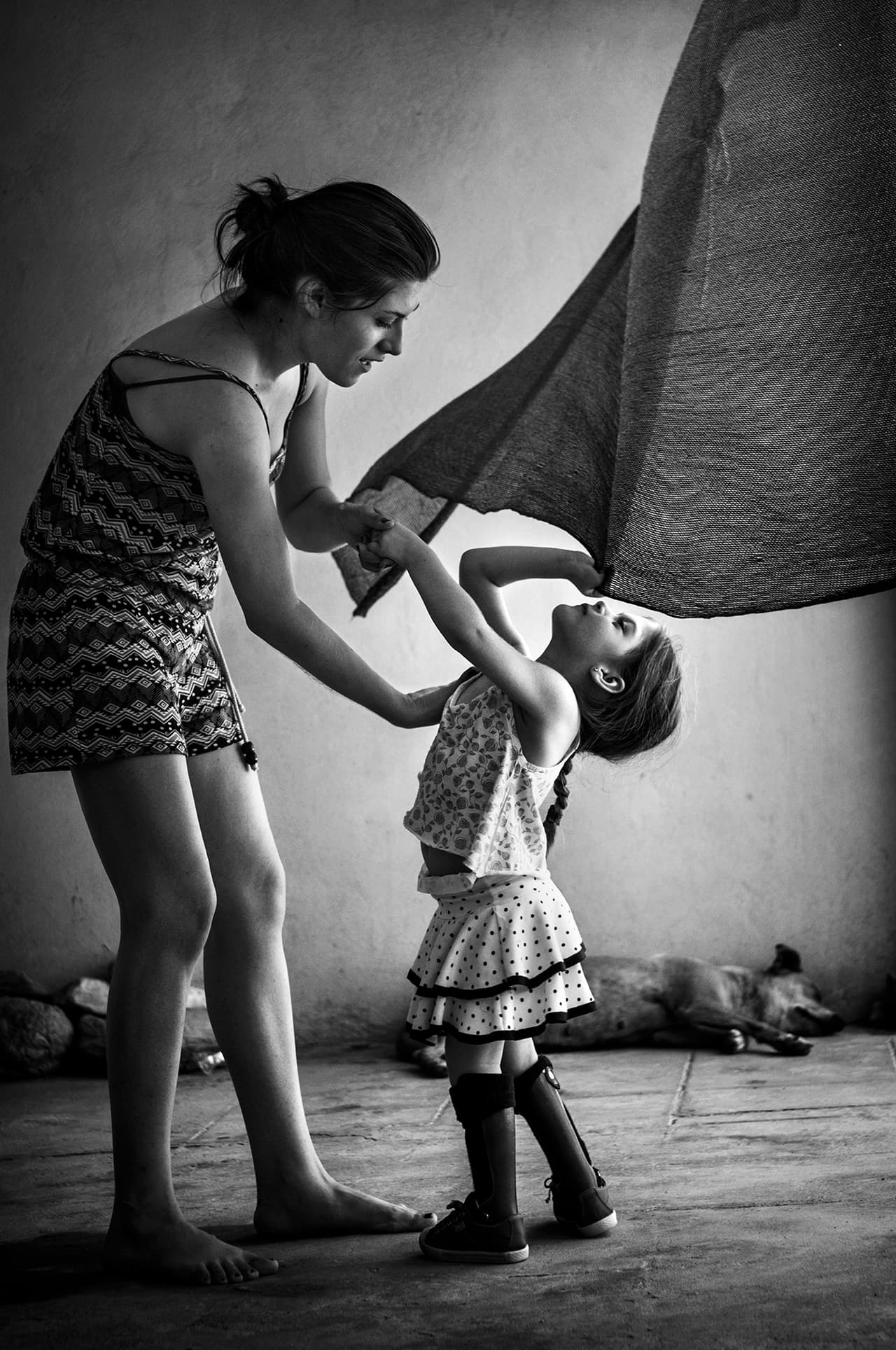 Anita Sosa (4 años) no puede caminar sola, pero juega soñando que es bailarina junto con su hermana mayor. Liliana Dworak, su madre, estuvo expuesta sustancias tóxicas que complicaron su último embarazo, cuando las autoridades fumigaron su casa para controlar el zancudo que propaga el dengue. Napenay, Provincia de Chaco, 2014.