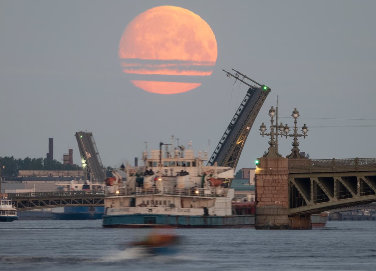 Imponente "luna de sangre" en el cielo de San Petersburgo, en Rusia, donde se ve un barco navegando por el río Neva.