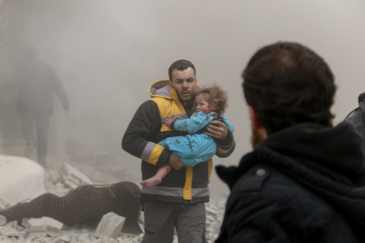 Un rescatista asiste a un pequeño sobreviviente de un bombardeo en Arbin, Guta Oriental, el 8 de febrero de 2018.