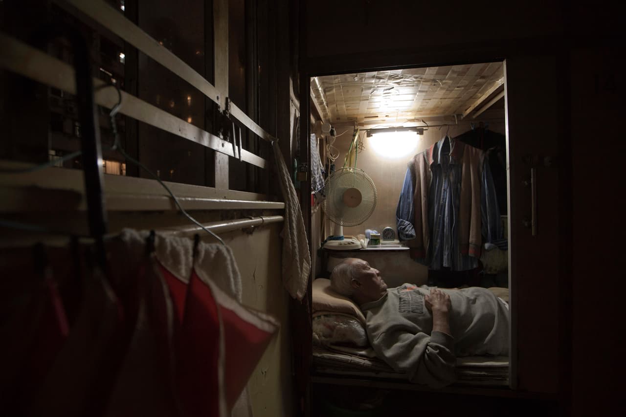 Tse Chu, un camarero jubilado, duerme en su ‘casa ataúd’. Es el lado oscuro de un boom de la vivienda en la ciudad.