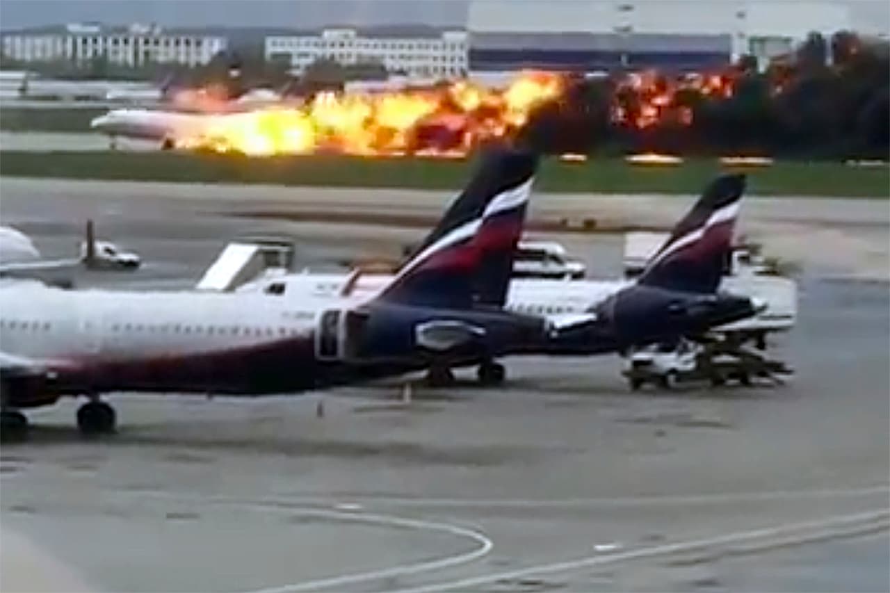 Esta imagen tomada de un video de un usuario de Instagram muestra el incendio del avión SSJ-100. Otros videos muestran a los pasajeros que son evacuados por los toboganes situados en la parte delantera del avión, y que corren alejándose de la nave que fue consumida por el fuego rápidamente.