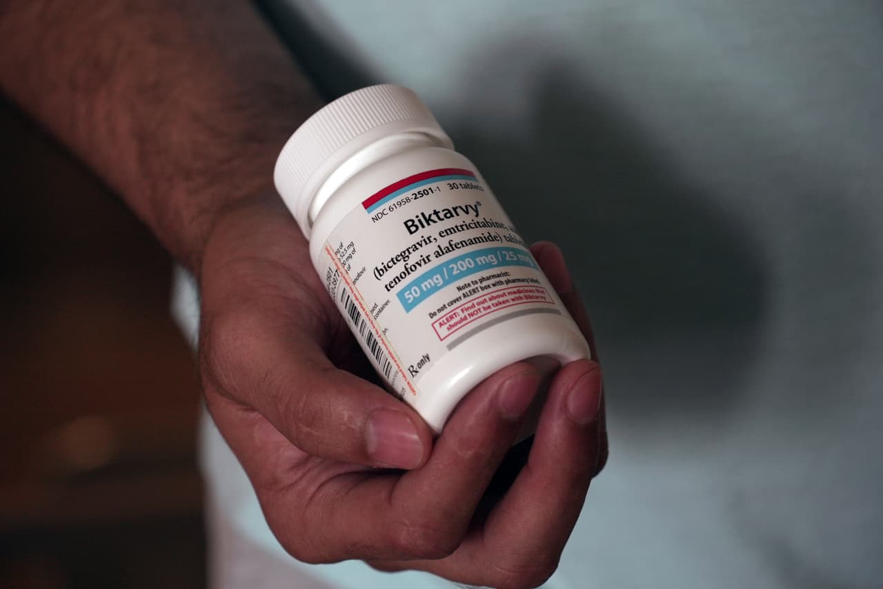 Fernando Hermida sostiene un frasco de Biktarvy, su medicamento contra el VIH, en Charlotte, Carolina del Norte, el 27 de mayo de 2024. Hermida recibió una factura de $1.275 a principios de este año por el medicamento, una de las razones por las que decidió mudarse para encontrar un tratamiento más asequible.