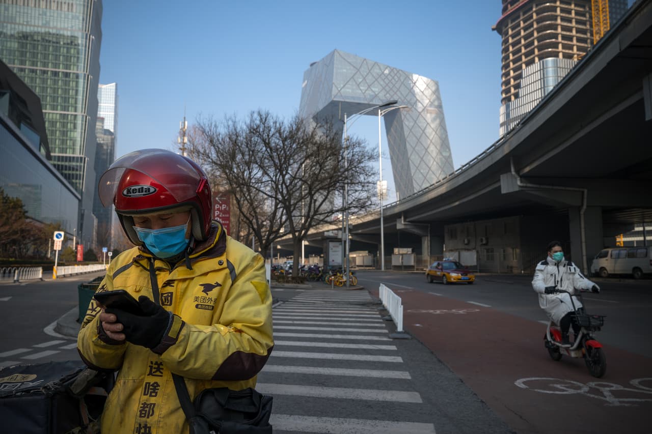 El coronavirus supera las 900 muertes en China y los 40,000 infectados a nivel mundial. Según el diario económico japonés Nikkei Asian Review, la posibilidad de que la suspensión del trabajo en las ciudades chinas se extienda causa preocupación en todo el mundo. En la fotografía un repartidor utiliza su teléfono en una calle desierta de Pekín.