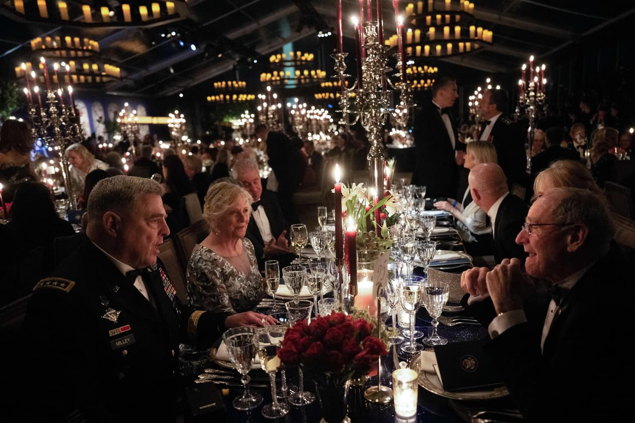El jefe del Estado Mayor Conjunto, Mark A. Milley, junto a otros comensales en la cena realizada el 1 de diciembre en el jardín sur de la Casa Blanca. Los puestos de mesa usados en la velada fueron alquilados porque la vajilla oficial no puede salir de la mansión presidencial. Las mesas fueron decoradas con lirios blancos, la flor oficial de Francia, reportó la AP.