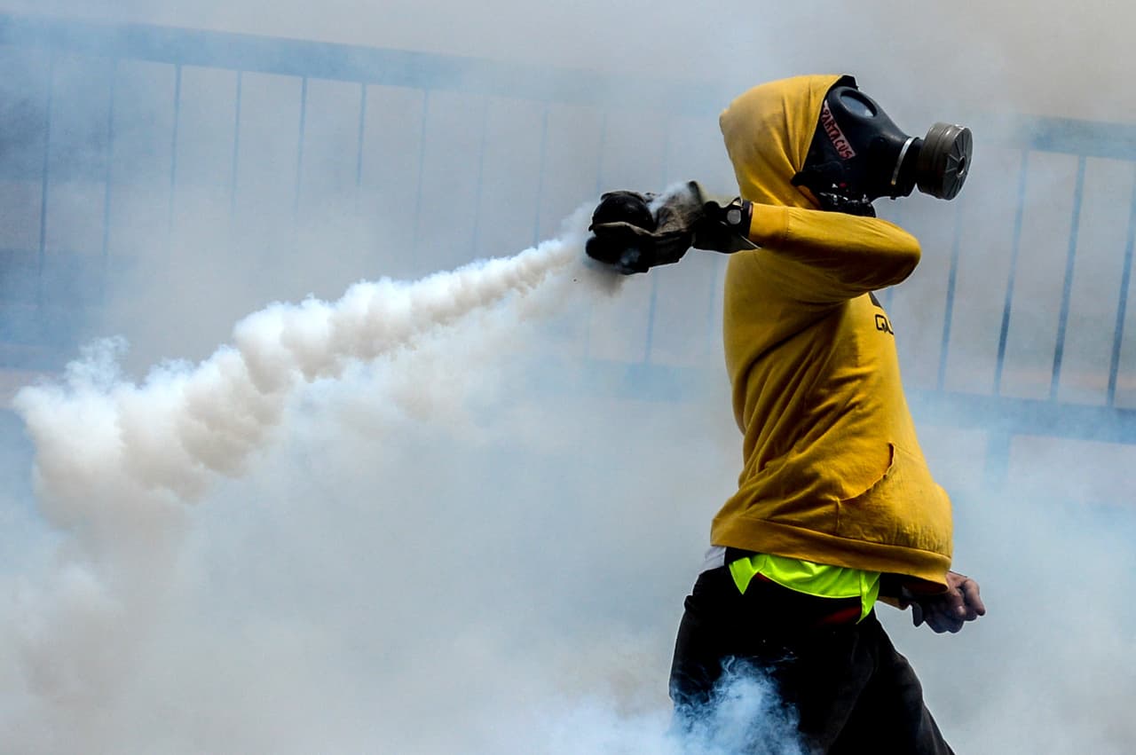 Un manifestante opositor regresa una bomba lacrimógena disparada por la policía. Caracas 8 de abril de 2017.