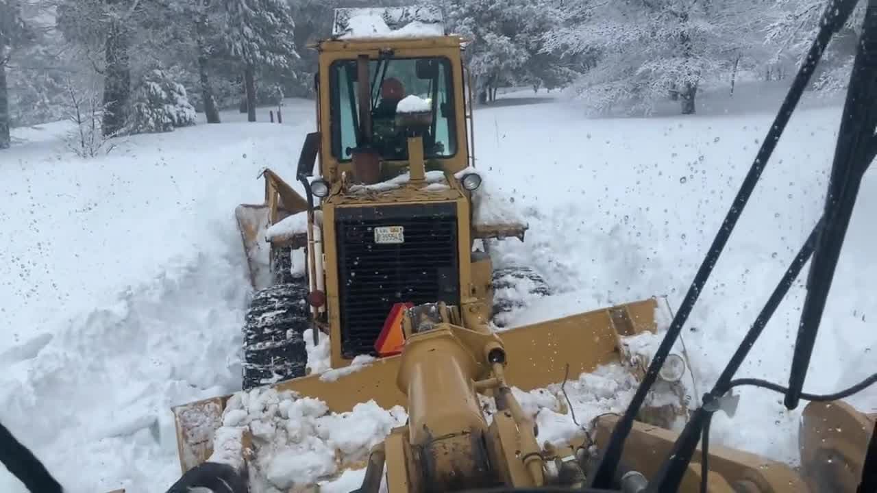 Las cuadrillas de Obras Públicas trabajan en Cedar Pines Drive en Cedarpines Park, ejecutando dobles utilizando un cargador para empujar otro debido a la extrema profundidad de la nieve.