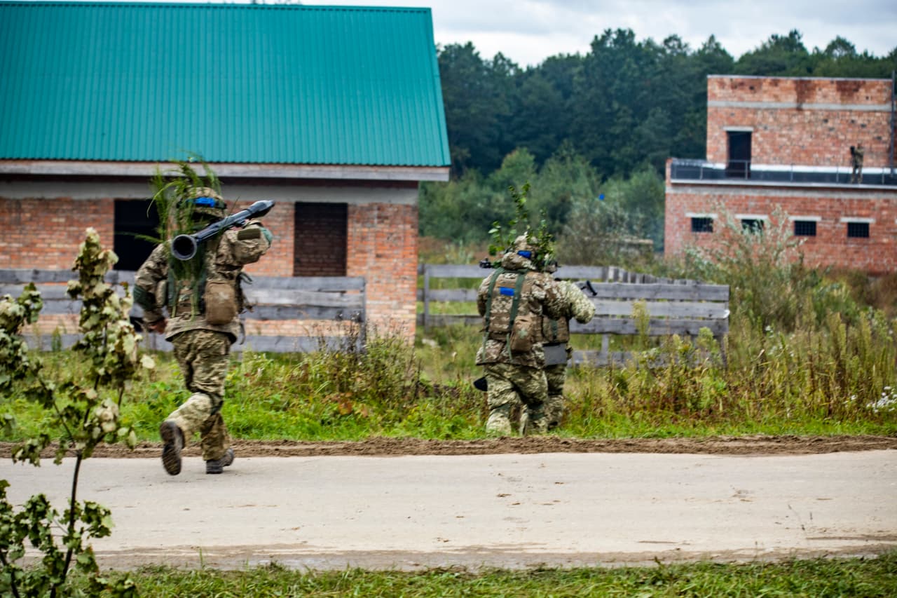 Soldados de las Fuerzas Armadas de Ucrania asaltan una aldea simulada durante el entrenamiento de Rapid Trident 2021. Desde 2014, los asesores militares de Estados Unidos han entrenado a más de 27,000 soldados ucranianos. El entrenamiento incluyó desde "fundamentos básicos" hasta la importancia de las tácticas de camuflaje y dispersión y las operaciones cibernéticas.