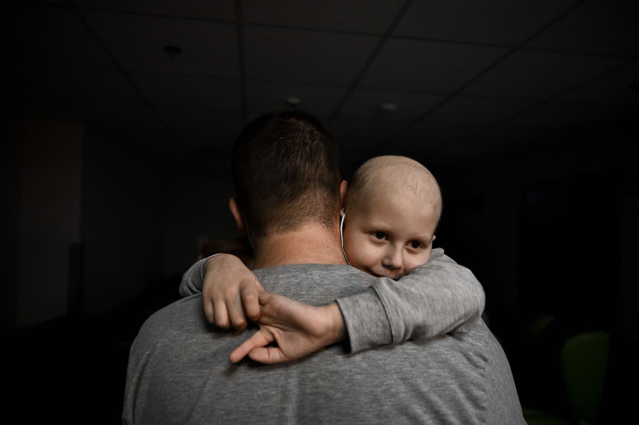 Un adulto sostiene a un pequeño que recibe tratamiento contra el cáncer en el centro de oncología de Kiev, el 28 de febrero. Los pacientes fueron llevados al sotano del edificio para resguardarlos de los bombardeos.
<br>