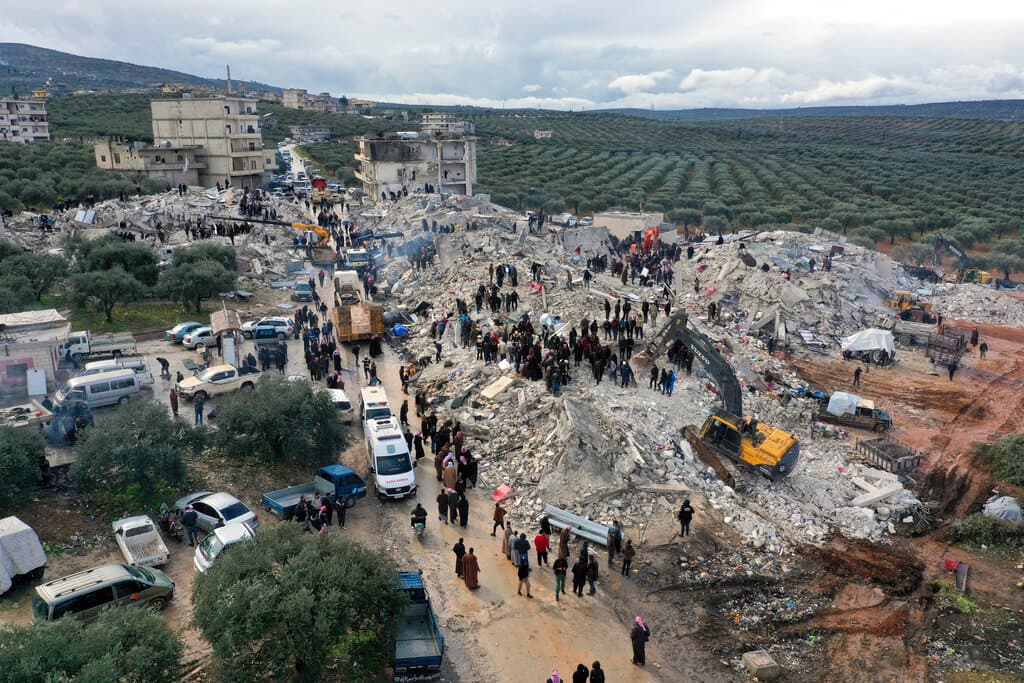 Trabajadores de defensa civil y residentes buscan entre los escombros de edificios derrumbados en la ciudad de Harem, cerca de la frontera turca, provincia de Idlib, Siria, lunes 6 de febrero de 2023.