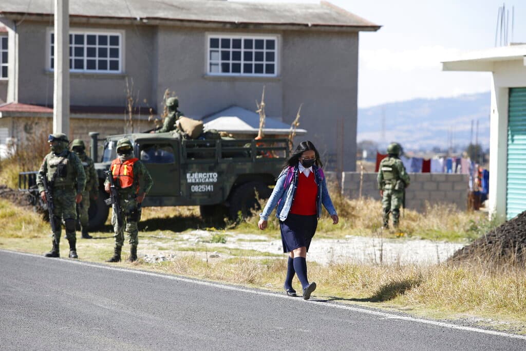 Una estudiante camina por una calle luego de traspasar un punto de control cerca de la prisión de Almoloya, donde está recluido Ovidio Guzman, quien se dio a conocer en todo México el 17 de octubre de 2019, cuando las autoridades mexicanas 
<a href="https://www.univision.com/noticias/america-latina/culiacanazo-el-operativo-fallido-de-2019-para-capturar-a-ovidio-guzman-y-que-termino-con-la-orden-de-amlo-para-liberarlo">lo detuvieron para liberarlo posteriormente</a> por orden del presidente Andrés Manuel López Obrador, en medio de una asonada criminal conocida como el 'Culiacanazo'.