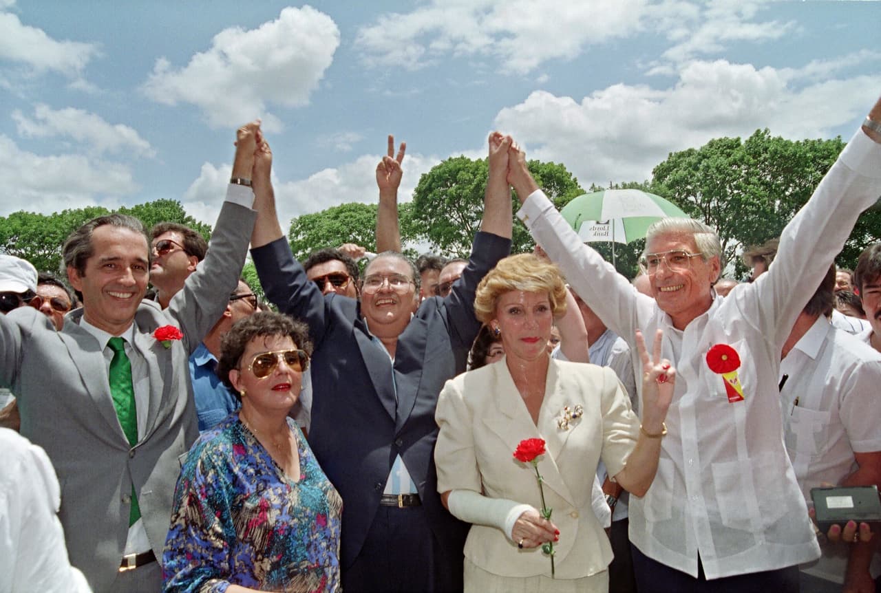El candidato presidencial Guillermo Endara (centro), de la Alianza Democrática de Oposición Civilista (ADOC), saluda a una multitud junto con sus compañeros vicepresidenciales Ricardo Arias Calderón (izquierda) y Guillermo Ford (derecha) después de emitir su voto el 7 de mayo de 1989 en Ciudad de Panamá.
