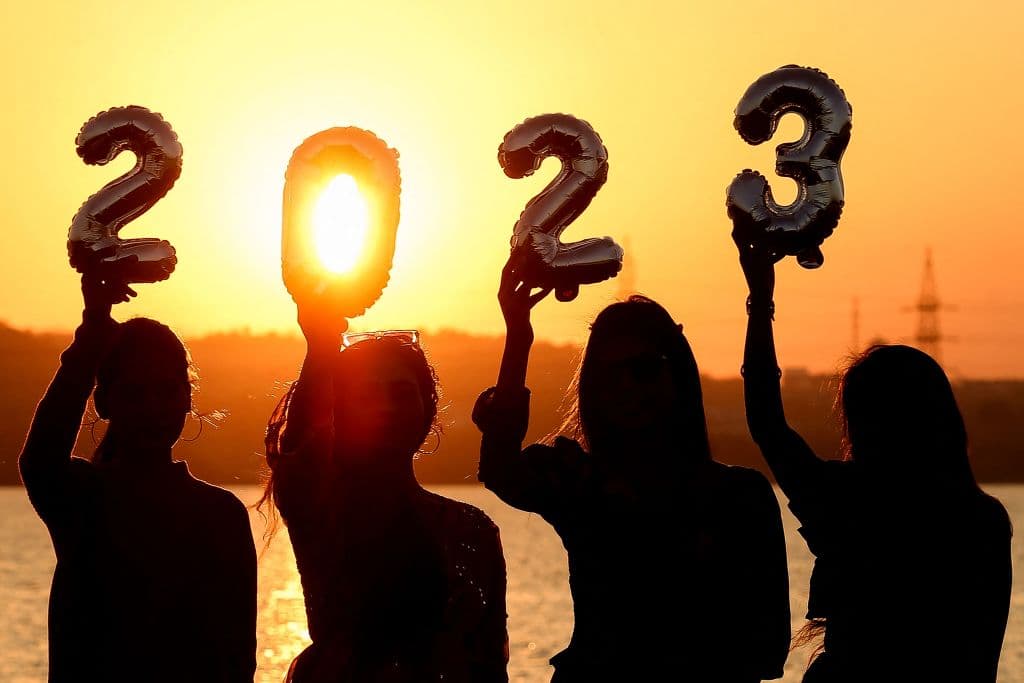 Mujeres sostienen globos que forman el año 2023 mientras se ponía el sol en Bhopal, India.