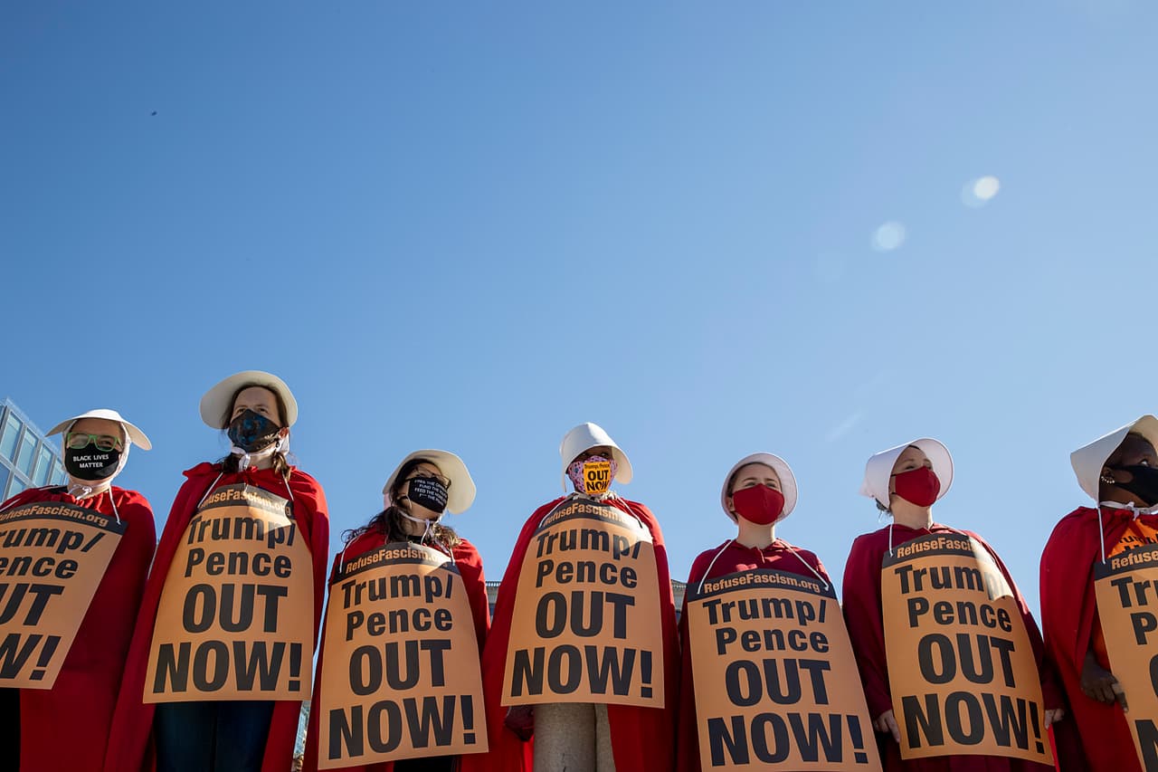Algunas asistieron portando disfraces de mucamas, en alusión a 'El cuento de la criada' ('The Handmaid's Tale'), una obra que critica el trato a las mujeres en una sociedad dominada por los hombres. Por eso, portaban letreros que decían "Trump/Pence Fuera ya". La jueza nominada por Trump tiene 
<a href="https://www.univision.com/noticias/elecciones-en-eeuu-2020/los-inquietantes-nexos-de-la-jueza-amy-barret-con-el-grupo-ultraconservador-gente-de-alabanza">vínculos </a>con el grupo ultraconservador Gente de Alabanza, una comunidad religiosa que sostiene que los hombres son divinamente ordenados como "cabeza" de familia.