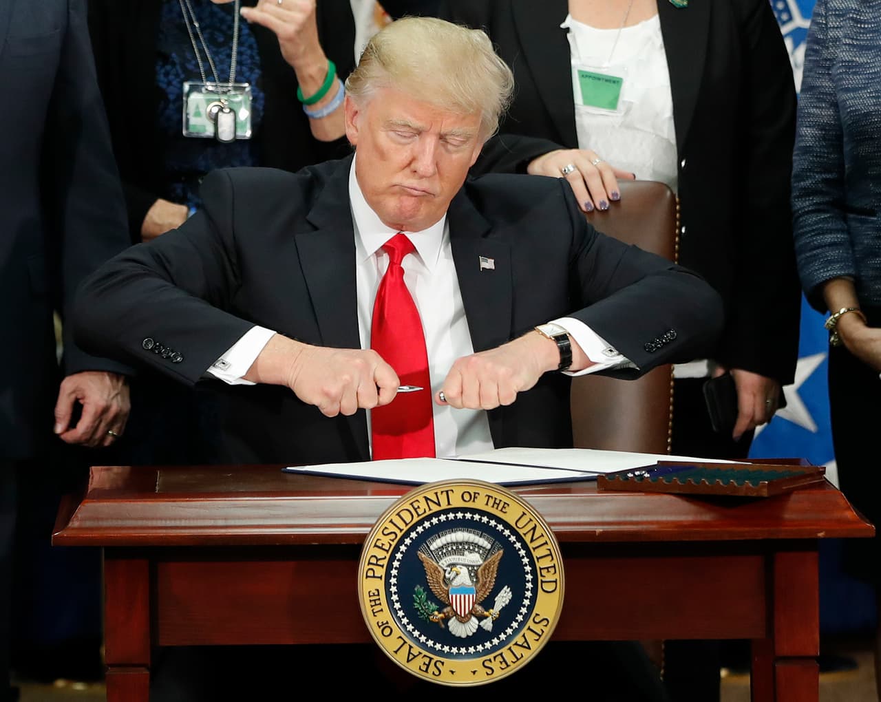 <b>Contra la inmigración por decreto.</b> Desde que asumió la presidencia, Donald Trump ha utilizado las 
<a href="https://www.univision.com/noticias/politica/estos-son-los-39-principales-decretos-firmados-por-trump-explicados"><u>órdenes ejecutivas</u></a> para imponer las políticas de ‘tolerancia cero’ sin pasar por el Congreso. Con este instrumento ha intentado impulsar su proyecto de muro fronterizo, penalizar a las ciudades santuarios, establecer deportaciones expeditas, endurecer los requisitos de asilo, vetar la entrada de ciudadanos de países musulmanes, revisar el programa de visas H-1B y reducir la cuota para la entrada de refugiados. En la fotografía, 
<b>la firma de la orden ejecutiva del 25 de enero de 2017, contra las ciudades santuarios y a favor del muro.</b>