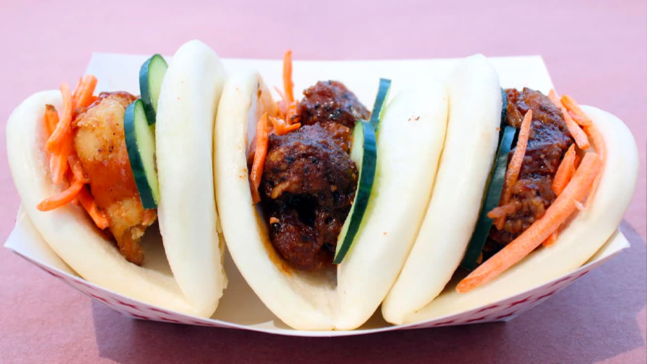 <b>BAO BUN TACO TRIO</b> de East Meets West BBQ Fusion 
<br>Lo describen como todo un 
<i>“paraíso para los amantes de la carne”</i>. Uno viene relleno de pollo frito, otro de cerdo y el tercero de panza. 
<b>Puedes probar uno o ¡el trío completo!</b>