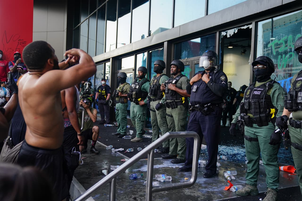 Oficiales de policía custodian el Centro CNN durante una protesta el 29 de mayo de 2020 en Atlanta, Georgia. Los manifestantes causaron destrozos a la fachada del edificio.