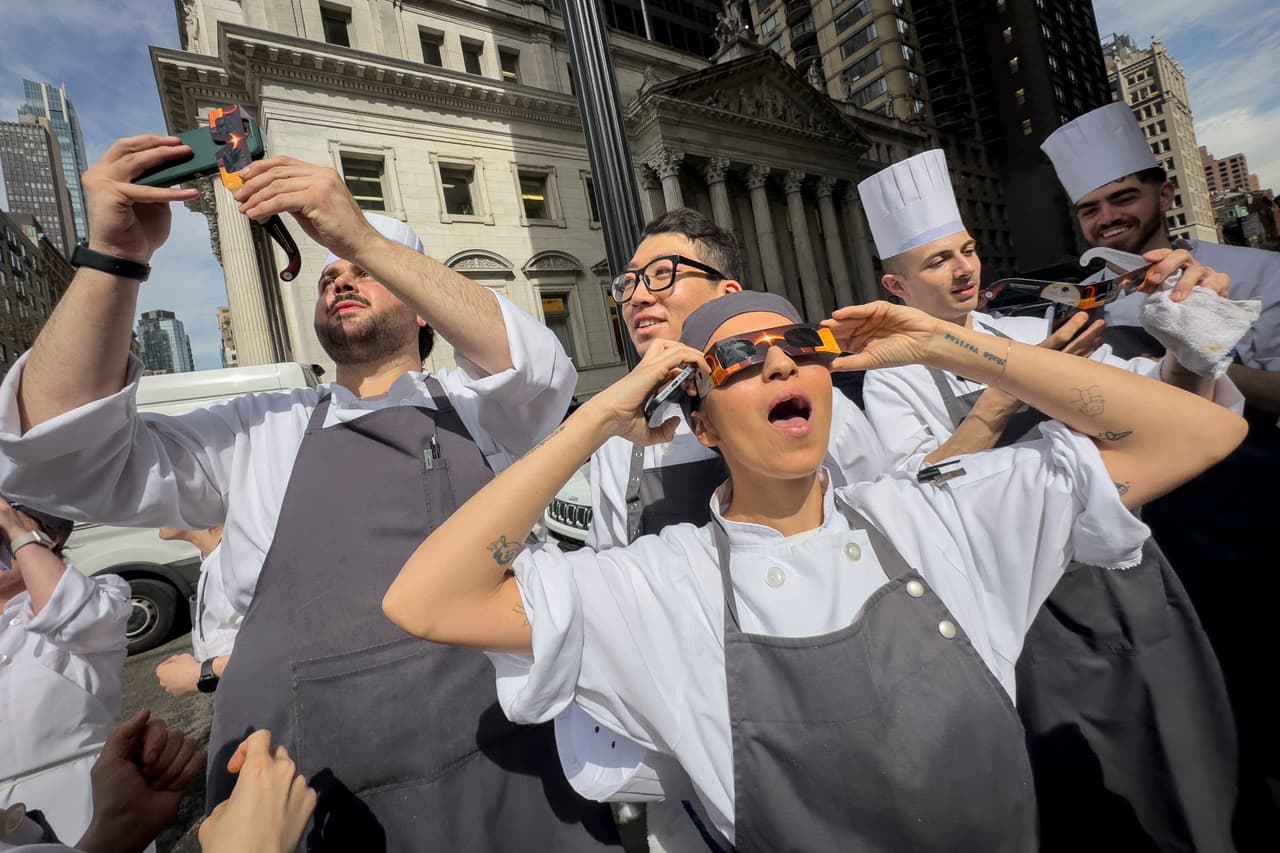 Trabajadores de un restaurante en Manhattan toman un descanso para salir a ver 
<a href="https://www.univision.com/noticias/asi-se-vio-desde-el-espacio-como-el-eclipse-oscurecio-parte-de-la-tierra-video">el eclipse solar total del 8 de abril de este año.</a> Ciudades como San Antonio y Dallas, en Texas, pudieron disfrutar de la penumbra completa del fenómeno, mientras que zonas desde Mazatlán, México, hasta el norte de ese país también lo apreciaron.