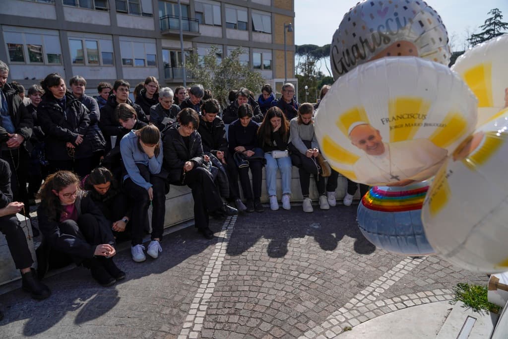 Personas rezan por la salud del papa Francisco este domingo, frente a la clínica Gemelli de Roma, en donde está ingresado.