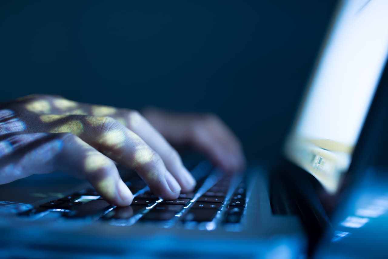 Close-up image of software engineer typing on laptop