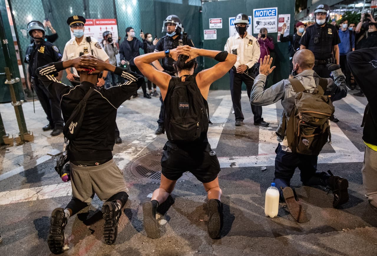 Manifestantes se arrodillan frente a policías de Nueva York durante una marcha en Manhattan el 31 de mayo de 2020.