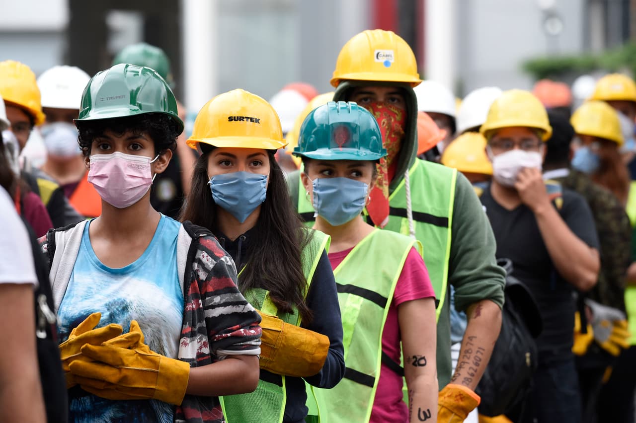 Una fila de jóvenes con cascos y guantes nuevos esperan con miradas ansiosas por la oportunidad de ayudar.