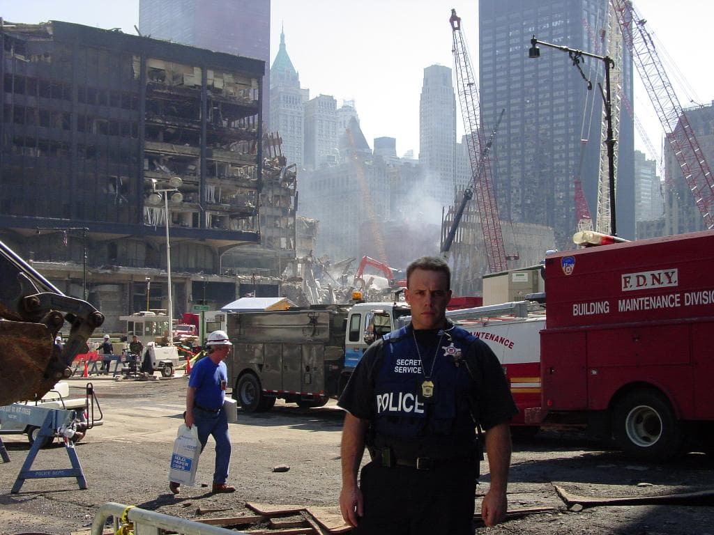 Miembro del USSS en primer plano con un camión de bomberos detrás en la Zona Cero de Nueva York, durante los trabajos de recuperación tras el atentado. 
<br>