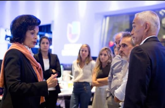 Bianca Jagger (l) visiting Univision in August 2017, talking to Jorge Ramos (r) and other members of staff.
