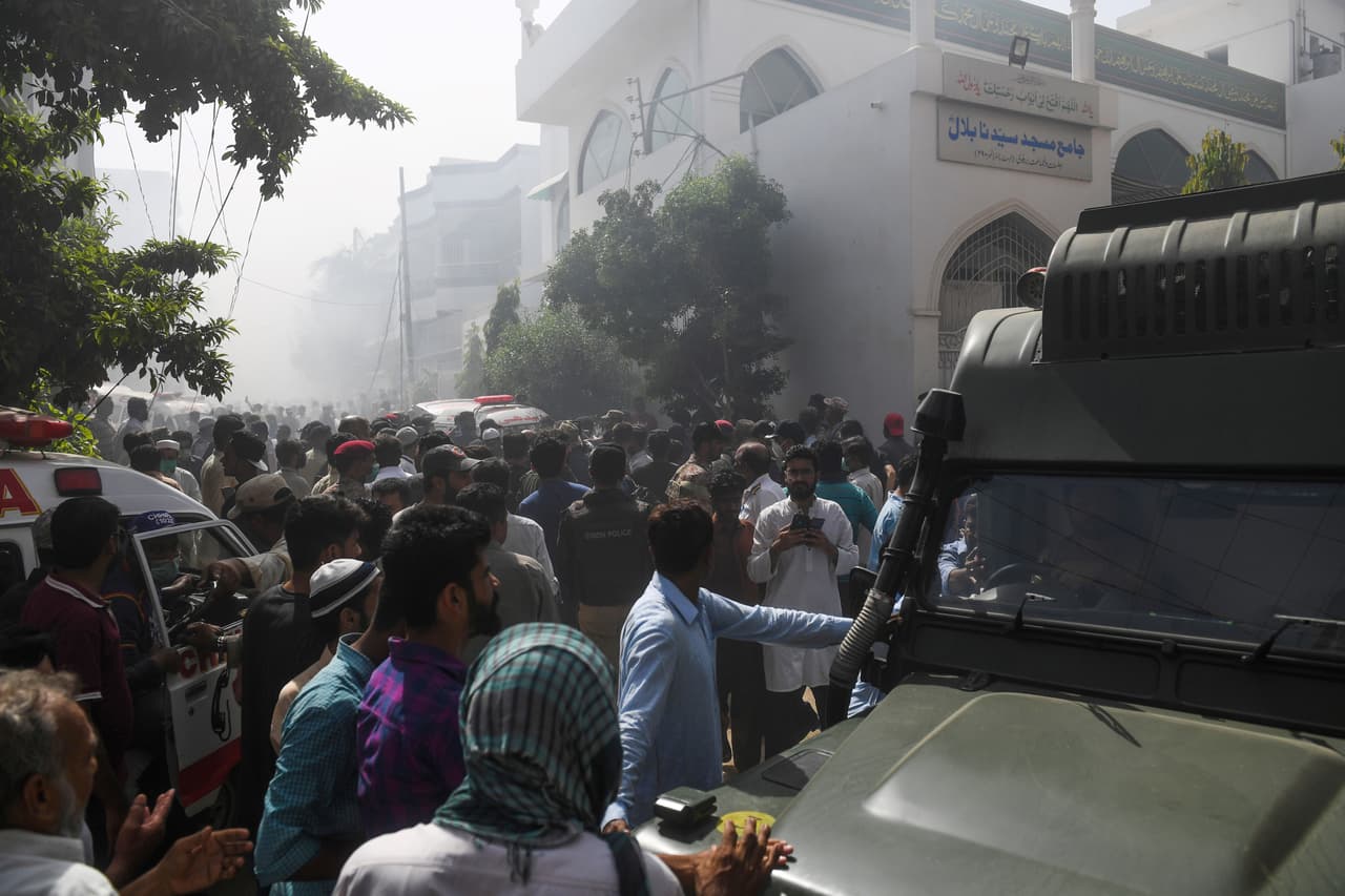 Rescatistas y vecinos cerca del lugar donde cayó a tierra el avión de Pakistan International Airlines. Llevaba 91 pasajeros y 7 tripulantes, dijeron a la agencia AFP autoridades de aviación de Pakistán.