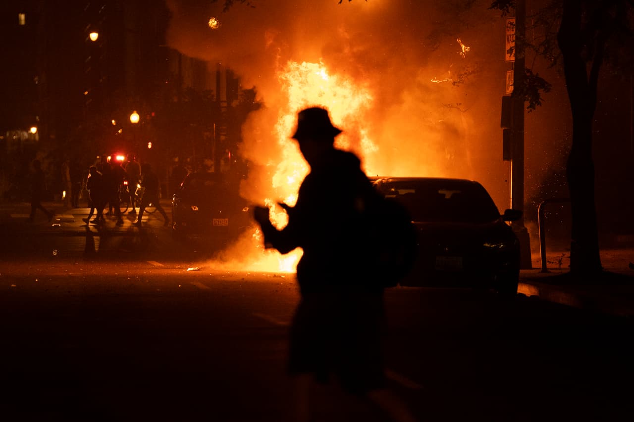 Un manifestante ve un automóvil quemarse durante una protesta por la muerte de George Floyd, cerca de la Casa Blanca en Washington.