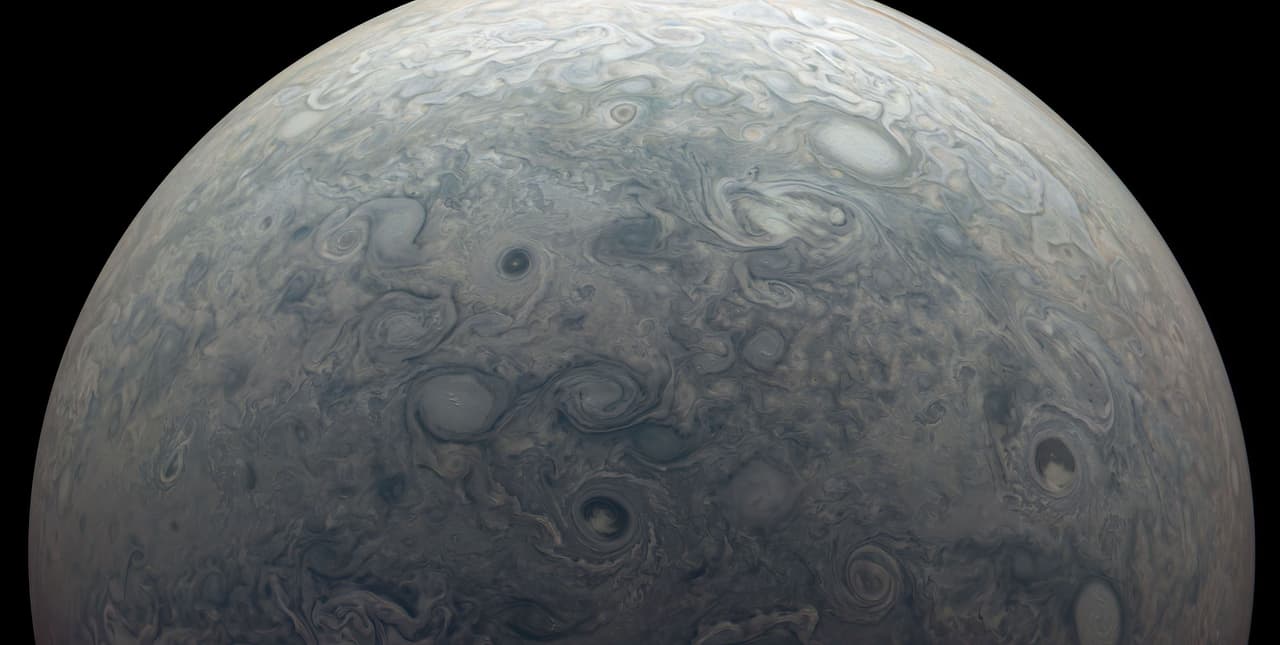 La turbulenta atmósfera de Júpiter en el norte del planeta. Utilizando los instrumentos de Juno, los científicos descubrieron que los vientos se extienden a más de 1,800 millas (3,000 kilómetros) de profundidad, donde el material más bajo en la atmósfera de Júpiter es altamente conductor eléctricamente. “Se descubrió que el viento corta toma material conductor y lo transporta por todo el planeta, lo que cambia la forma del campo magnético”, explica la NASA.
<br>
